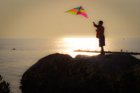 Boy Flies Kite into the Sunset
